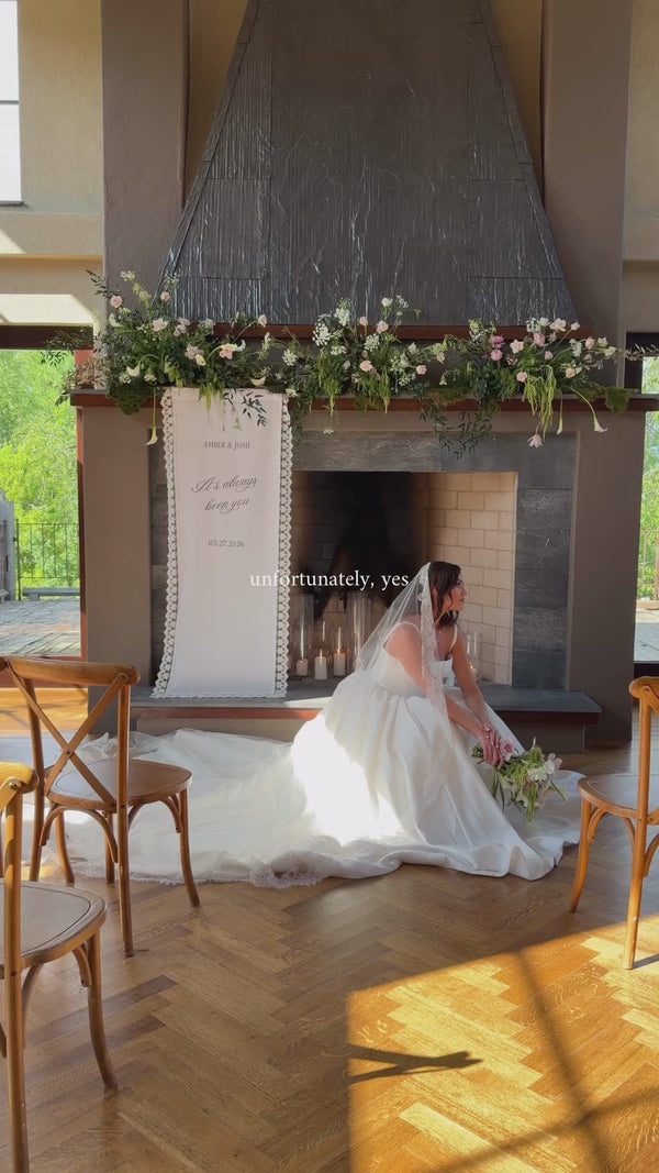 Bride beside a Made & True wedding sign at a fireplace styled shoot